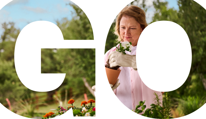 Tracey, a GOCOVRI patient, gardening in her backyard while wearing gloves.